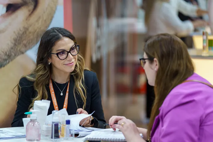 Duas mulheres conversando em uma mesa durante o evento